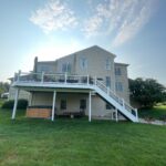 House with a white wooden porch leading upstairs to the second floor.