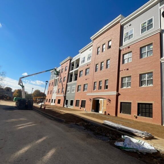 Apartment Pressure Washing Service being performed on brick and gray apartments.